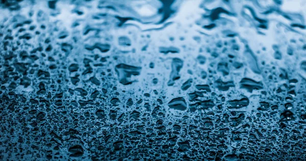 Vatten textur abstrakt bakgrund, aqua droppar på blått glas som s — Stockfoto