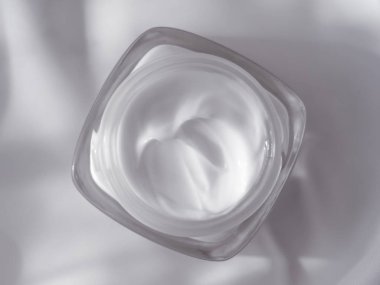 İpek arka planda yüz kremi nemlendirici kavanozu, nemlendirici cilt