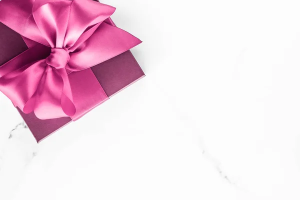 Рожева подарункова коробка з шовковим бантом на мармуровому фоні, дитяче шоу — стокове фото