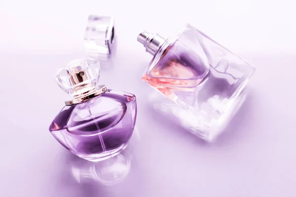 Fialová láhev parfému na lesklém pozadí, sladká květinová vůně, — Stock fotografie