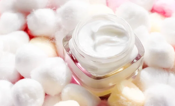 Luxury face cream for sensitive skin and eco cotton balls on bac