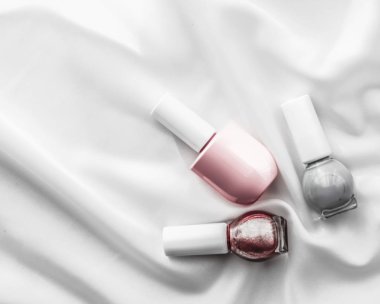 İpek arka planda oje şişeleri, Fransız manikür ürünleri.