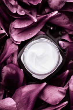 Pembe çiçek çantasındaki yüz kremi nemlendiricisi.