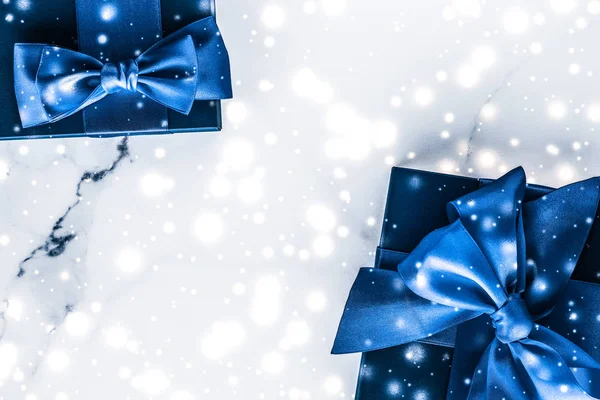 Scatola regalo per le vacanze invernali con fiocco di seta blu, brillantini da neve su marb — Foto Stock