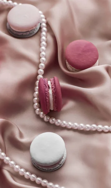 Sweet macaroons and pearls jewellery on silk background, parisia — ストック写真