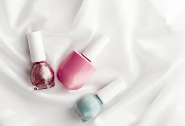 İpek arka planda oje şişeleri, Fransız manikür ürünleri.