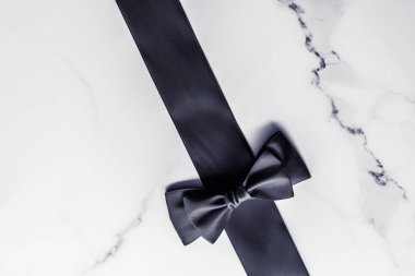 Siyah ipek kurdele ve yay mermer arka planda, yatık