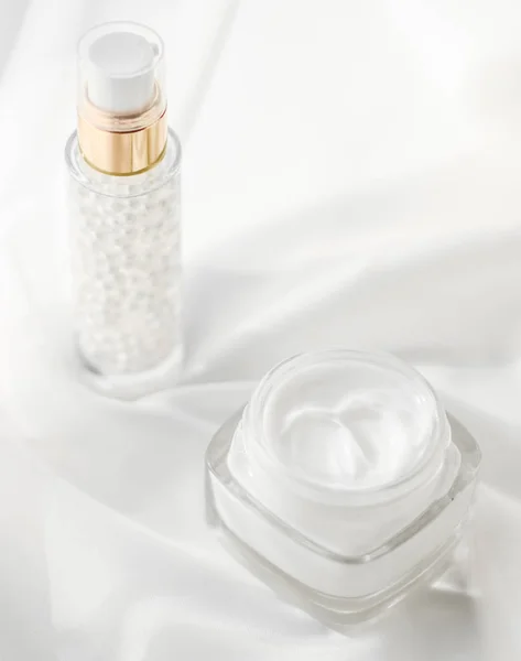 Crema facial hidratante tarro y gel de suero en seda blanca, coche de la piel — Foto de Stock