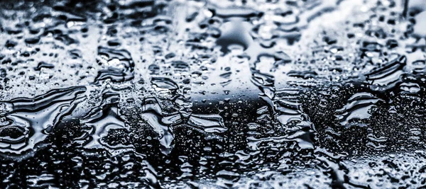 추상적 인 배경의 물 질감, 물은 유리처럼 은 유리 위에 떨어진다 — 스톡 사진