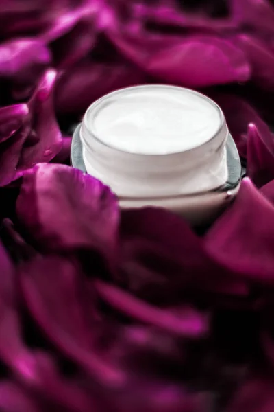 Creme hidratante de cuidados com a pele sensível em pétalas de flores roxas bac — Fotografia de Stock