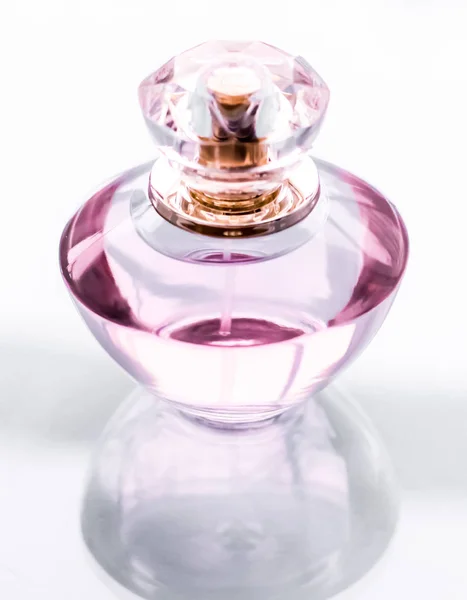 Frasco de perfume rosa no fundo brilhante, aroma floral doce, gl — Fotografia de Stock