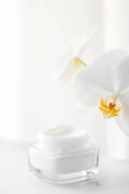 Yüz kremi kavanozu ve orkide çiçeği, nemlendirici cilt 