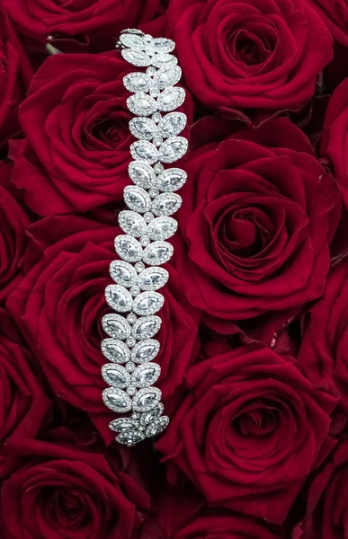 Luxus gyémánt ékszerek karkötő és piros rózsa virágok, szerelmi ajándék — Stock Fotó