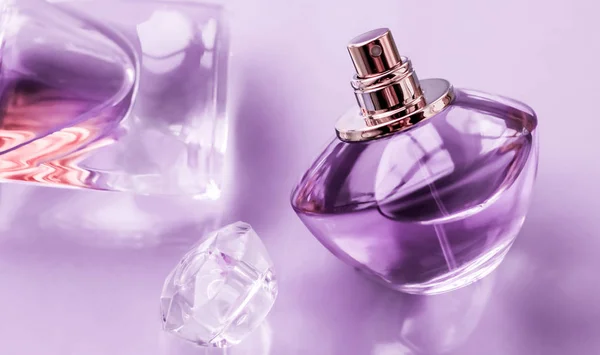 Purple perfume bottle on glossy background, sweet floral scent,