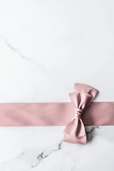 米色丝带和大理石背景的蝴蝶结，迷人的礼物 — 图库照片