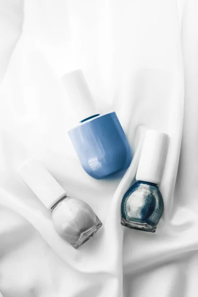 Smalto per unghie bottiglie su sfondo di seta, prodotti manicure francese — Foto Stock