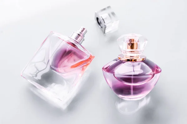 Růžová láhev parfému na lesklém pozadí, sladká květinová vůně, gl — Stock fotografie