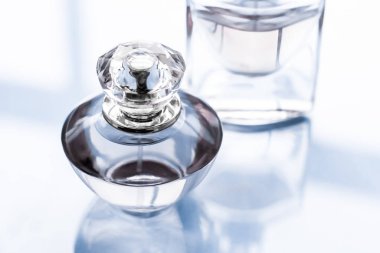 Parlak arka planda mavi parfüm şişesi, tatlı çiçek kokusu, gl