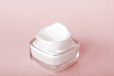 Bej arka planda yüz kremi nemlendirici kavanozu, nemlendirici kayak