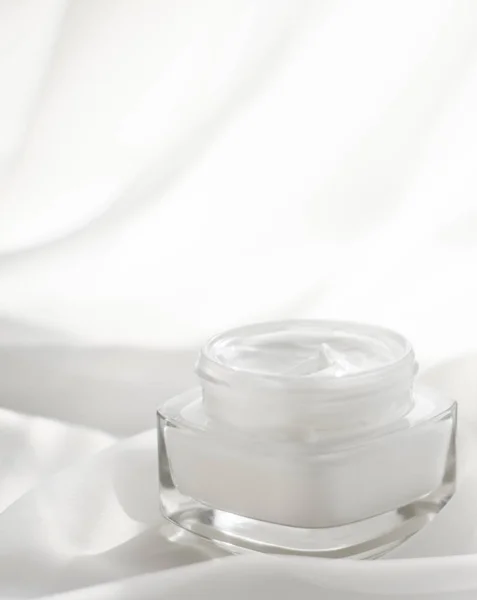 Crema facial hidratante tarro sobre fondo de seda, hidratante piel — Foto de Stock