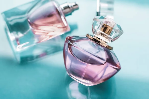 Bottiglia di profumo rosa su sfondo lucido, dolce profumo floreale, gl — Foto Stock