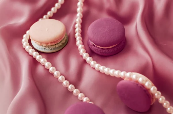 Sweet macaroons and pearls jewellery on silk background, parisia — ストック写真