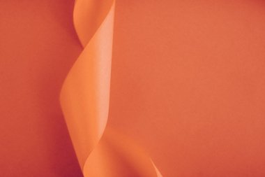 Turuncu arka planda soyut kıvrımlı ipek kurdele, özel lüks.