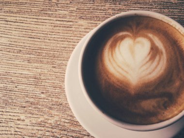 Bir kafeteryasıcak kapuçino Fincan, ahşap bir masada kahve i