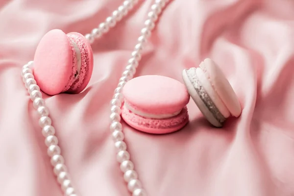 Sweet macaroons and pearls jewellery on silk background, parisia — ストック写真