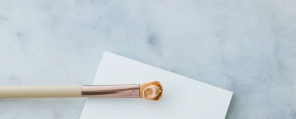 Makeup foundation bottle and contouring brush on marble, make-up — Stock Photo, Image