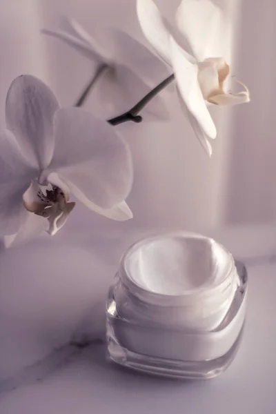 Crema facial hidratante tarro y flor de orquídea, hidratante piel — Foto de Stock
