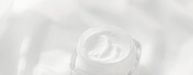 İpek arka planda yüz kremi nemlendirici kavanozu, nemlendirici cilt