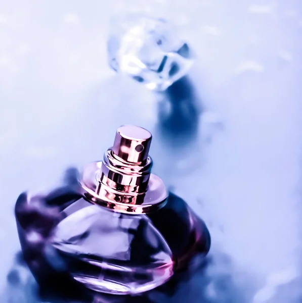 Парфюмерная бутылка под фиолетовой водой, свежий морской прибрежный аромат, как гл — стоковое фото