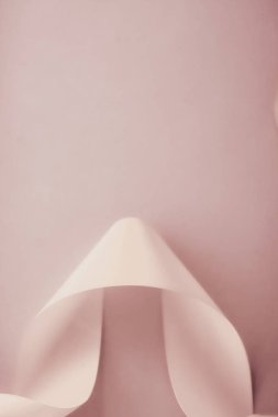 Pastel arka planda soyut kıvrımlı ipek kurdele, özel lüks.