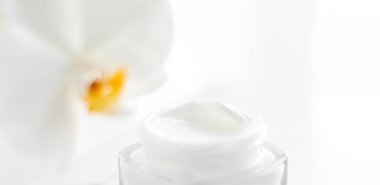 Yüz kremi kavanozu ve orkide çiçeği, nemlendirici cilt 