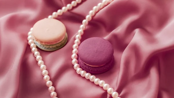 Sweet macaroons and pearls jewellery on silk background, parisia — ストック写真