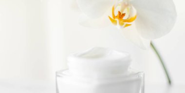 Yüz kremi kavanozu ve orkide çiçeği, nemlendirici cilt 