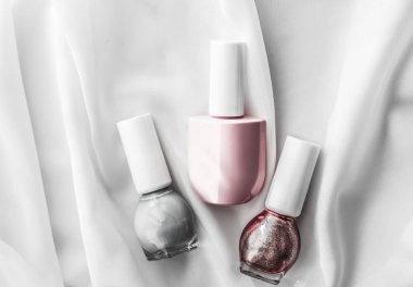 İpek arka planda oje şişeleri, Fransız manikür ürünleri.