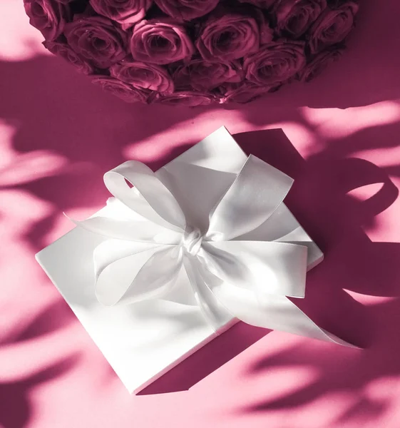 Luksusowe wakacje jedwabne pudełko i bukiet róż na różowym backgr — Zdjęcie stockowe