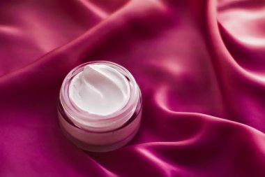İpek arka planda yüz kremi nemlendirici kavanozu, nemlendirici cilt