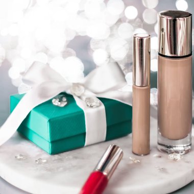 Tatil makyaj malzemesi, kapatıcı ve yeşil hediye kutusu.