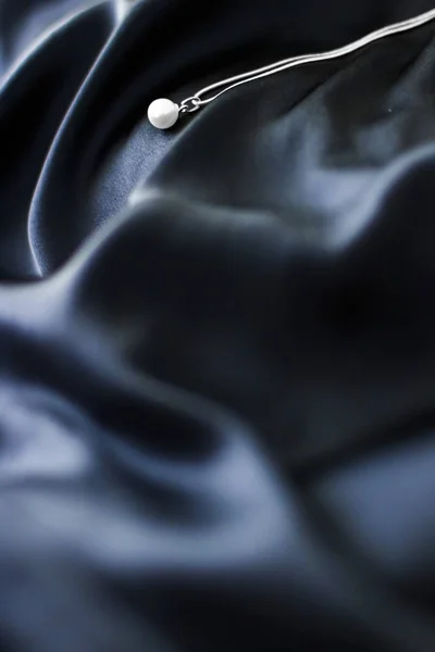 Luxuoso colar de pérolas de ouro branco no fundo de seda azul escuro, h — Fotografia de Stock