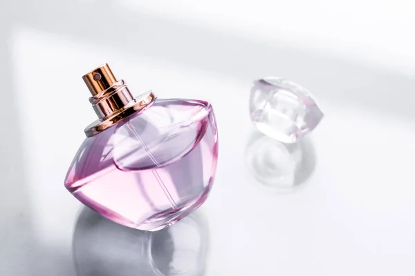 Rosa parfymflaska på blank bakgrund, söt blommig doft, gl — Stockfoto