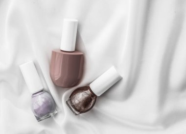 İpek arka planda oje şişeleri, Fransız manikür ürünleri.