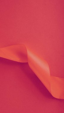 Gül arka planında soyut kıvrımlı ipek kurdele, özel lüks. 