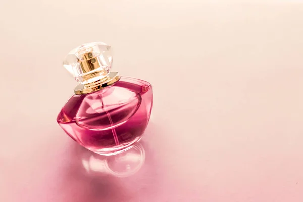 Bottiglia di profumo rosa su sfondo lucido, dolce profumo floreale, gl — Foto Stock