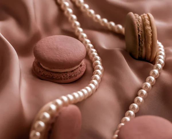 Sweet macaroons and pearls jewellery on silk background, parisia — ストック写真