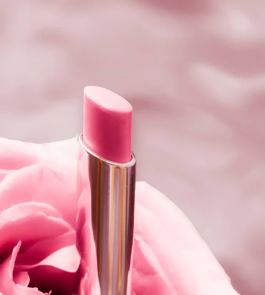 Lápiz labial rosa y flor de rosa sobre fondo líquido, impermeable g —  Fotos de Stock