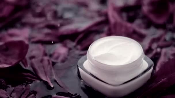 Gevoelige huidverzorging moisturizer gezicht crème op bloemblaadjes en water achtergrond, natuurwetenschappen voor de huid — Stockvideo