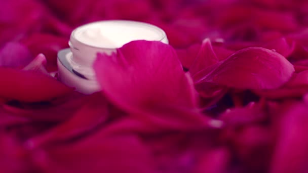 Crema facial hidratante para el cuidado de la piel sensible sobre pétalos de flores y fondo de agua, ciencias naturales para la piel — Vídeos de Stock